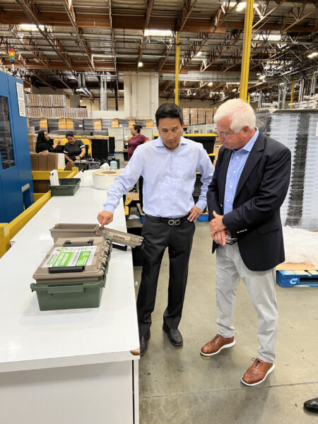 Steve Gwon of E-Solution Inc. (left) and Paul Caprio, president of sales at LS Mtron IMM USA, examine one of US Merchants’ new ammunition boxes. 
