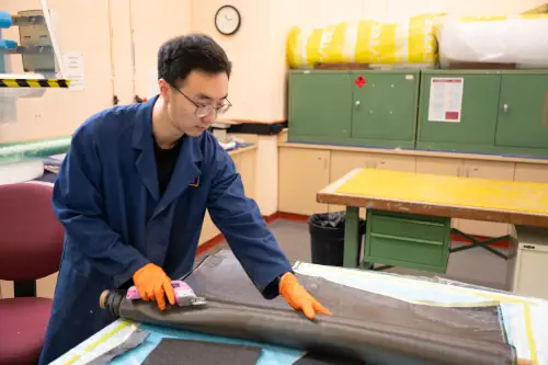 UNSW Canberra researcher Dr. Di He used sheets of carbon fiber to test his new method of recycling. He says his new approach resulted in 50 percent less degradation of the fiber. Courtesy of UNSW Canberra