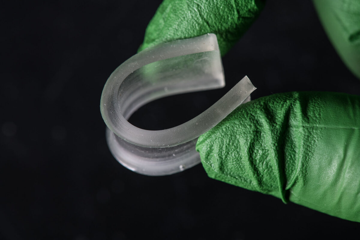 A researcher works with a sample of a rubbery, bio-based thiol-ene polymer in the Biofuel Research Lab at NREL’s Field Test Laboratory Building.