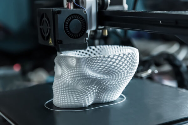 The 3D printer prints white plastic model of skull. modern technology.