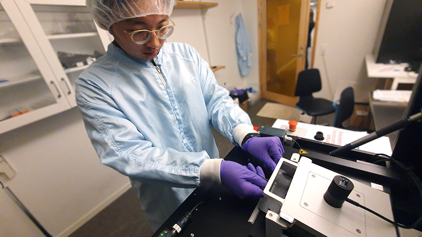 PhD student Lee-Lun Lai loads a tray into a 3D microprinter to demonstrate how polymer transistors can be made faster, cheaper and more sustainably.