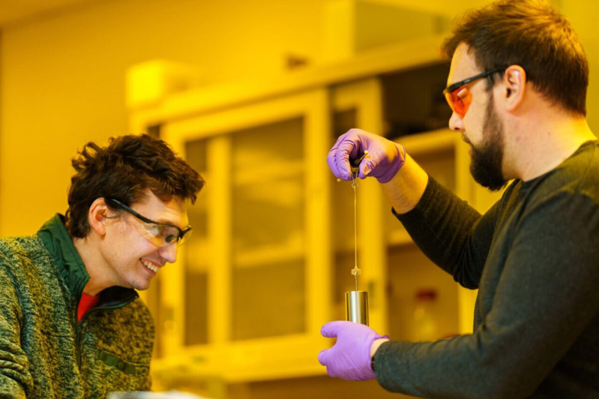 Samuel Leguizamon ( left) watches as Alex Commisso stretches 3D material that they printed at Sandia National Laboratories, using Selective Dual-Wavelength Olefin Metathesis 3D-Printing, or SWOMP.