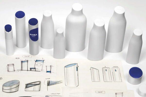 The Nivea bottle's rounded contours and embossed circular lid directly reference the classic blue tin, creating a cohesive design language that spans from heritage packaging to modern skincare formats. This structural consistency enables instant brand identification across 200+ countries. Design by fuseproject.