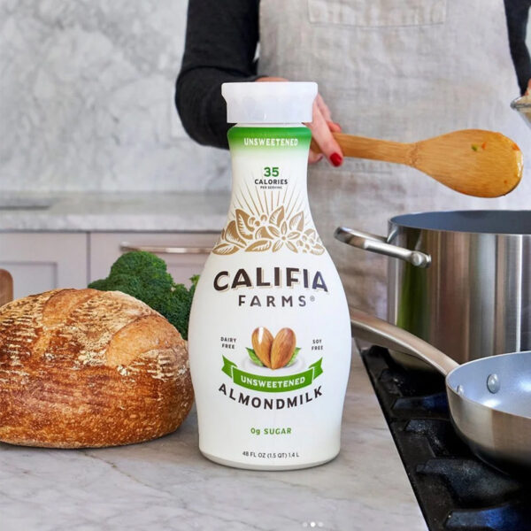 Califia Farms' signature curvy carafe bottles feature a distinctive hourglass silhouette with minimalist typography and hand-drawn botanical illustrations that evoke California's agricultural heritage. The innovative bottle shape disrupts traditional dairy aisle aesthetics by transforming plant-based milk into a premium, artisanal experience that stands apart from conventional rectangular cartons. Design by Farm Design.