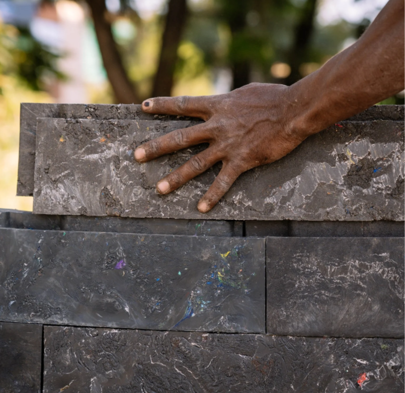 Builder constructing with Kubik’s interlocking building components made of upcycled plastic waste. Courtesy of Kubik.