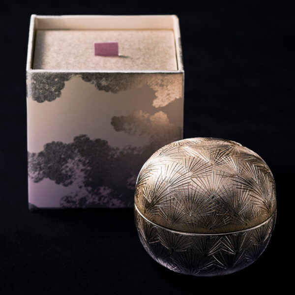 Sekkisei Miyabi Cream Nectar executes Japanese luxury codification through artisanal material vocabulary: hand-etched geometric botanical pattern on metallic spherical vessel evokes traditional craftsmanship. Design by Kosé Corporation.