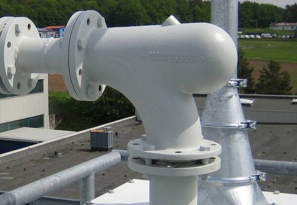Installed Gericke GB elbow for pneumatic conveying. The bend uses a special vortex chamber to change flow direction through product deflection rather than severe impact on the bend wall, which extends bend life and supports gentler handling of pellets and other bulk solids. Courtesy of Gericke.