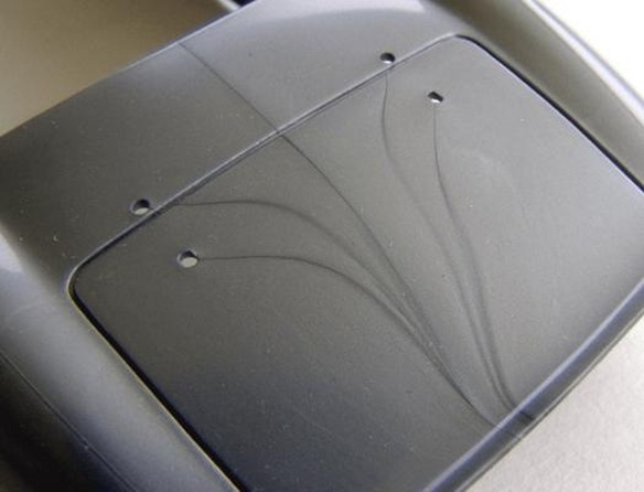 Flow marks and surface streaks can appear when melt flow, cooling, or viscosity changes during injection molding. In recycled-content parts, batch-to-batch variation can make these defects harder to control. Courtesy of Cavity Mold.